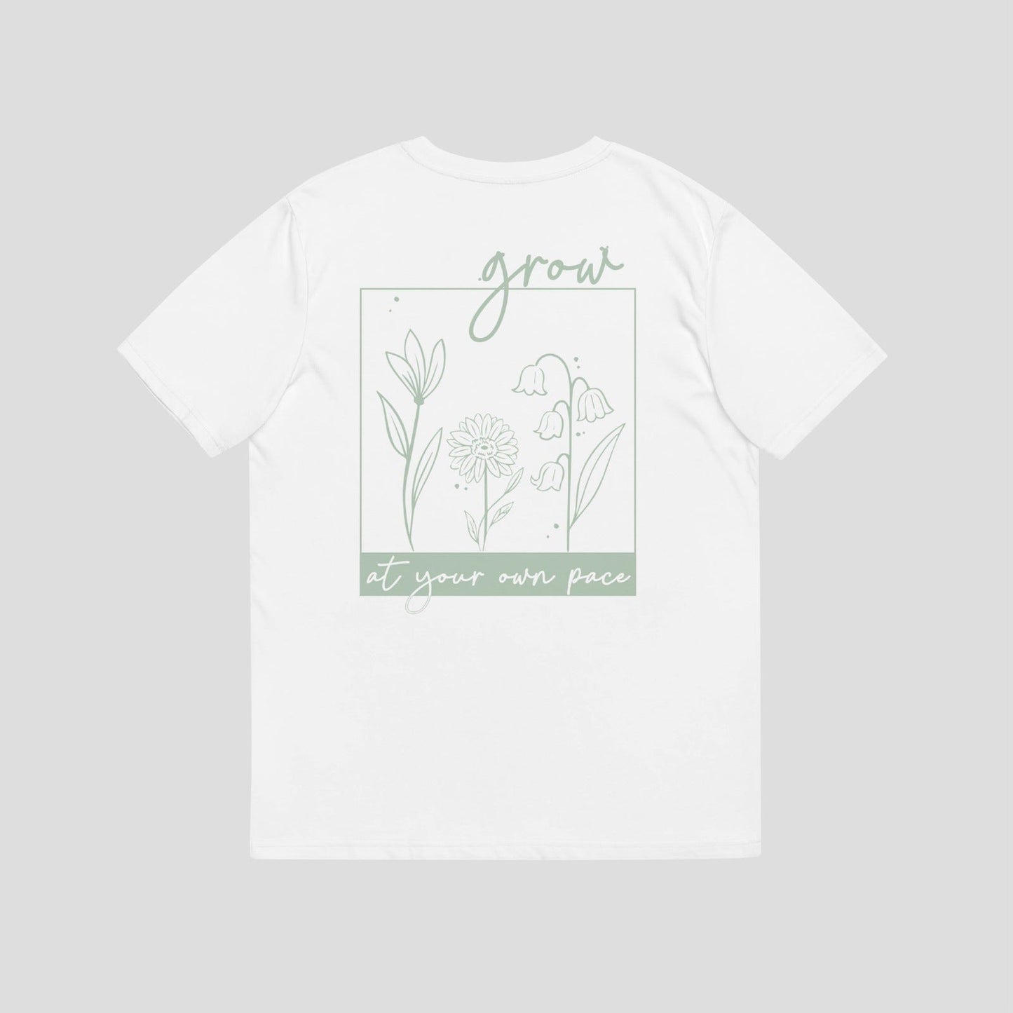 Grow At Your Own Pace Organic Tee deign depicts 3 flowers in a box with the word grow at the top in cursive and the words grow at you own pace at he bottom